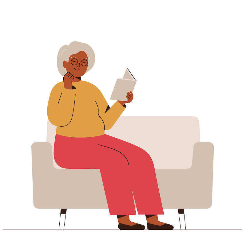Woman sat on couch reading a book